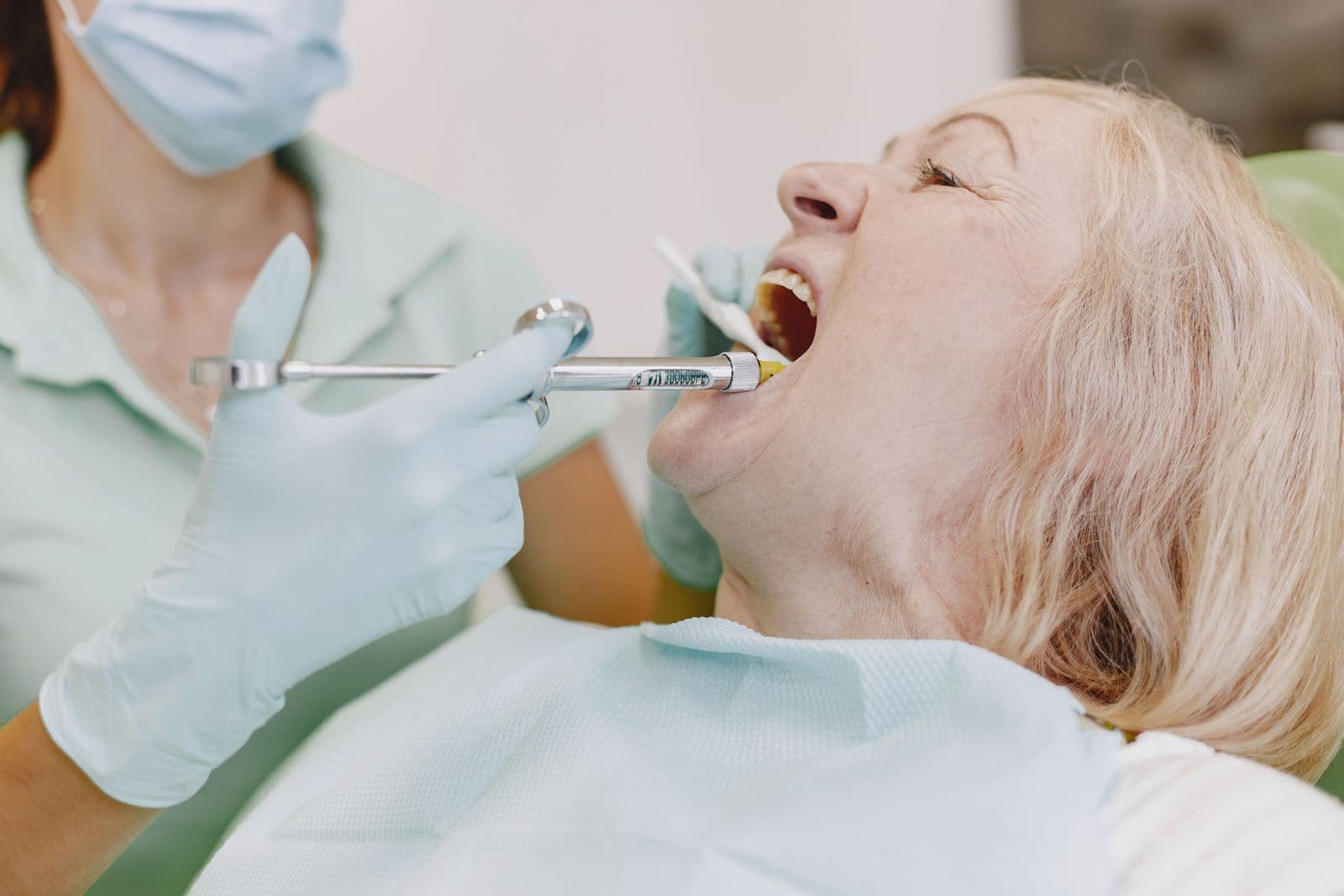 Dentist examining an elderly patient's gum health