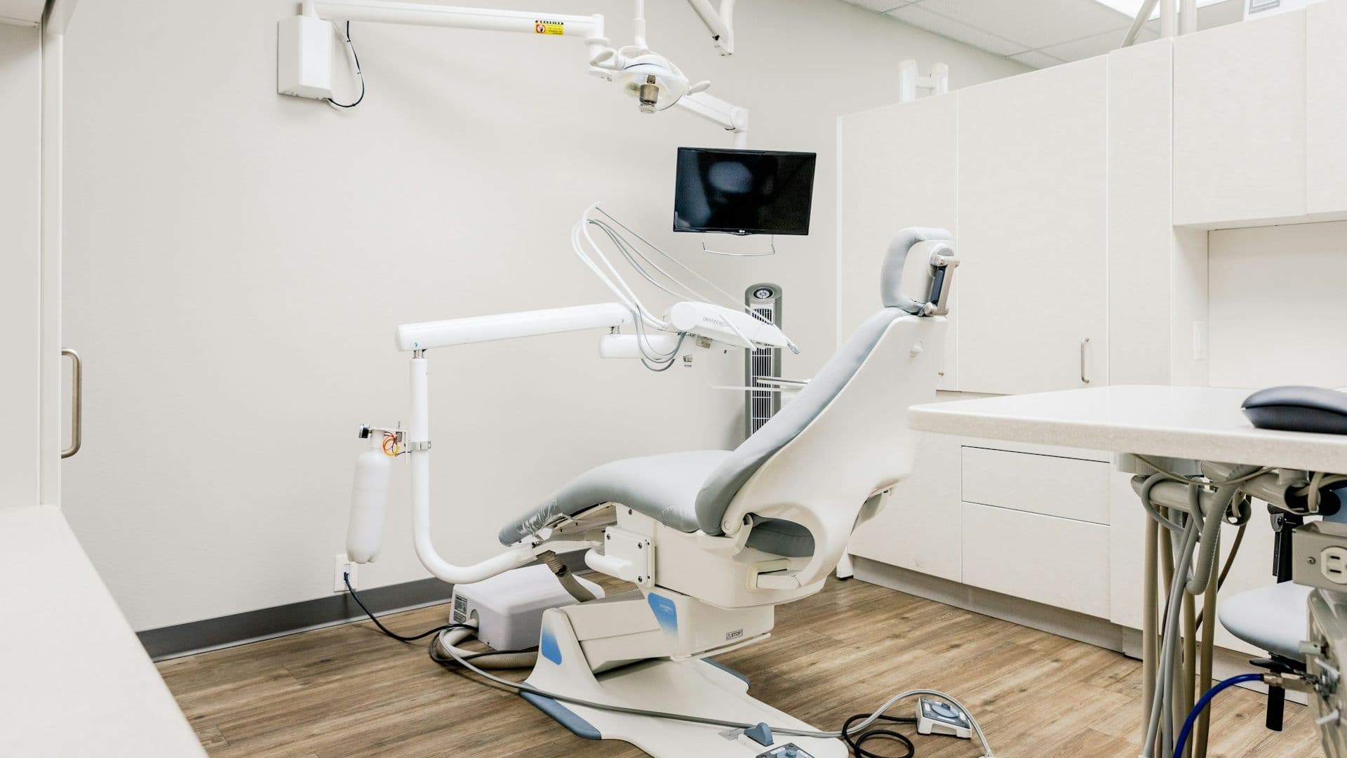 Image of a white dental chair within a white dental room. A day in the life of the dental practice manager at Distinctly Dental.