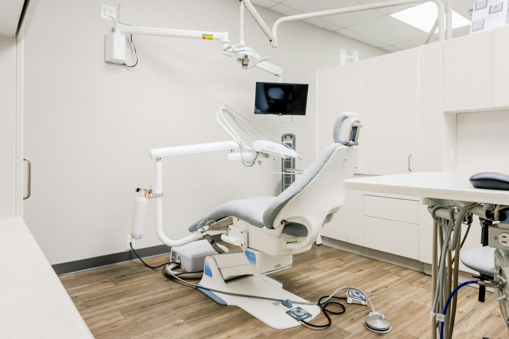 Image of a white dental chair within a white dental room. A day in the life of the dental practice manager at Distinctly Dental.